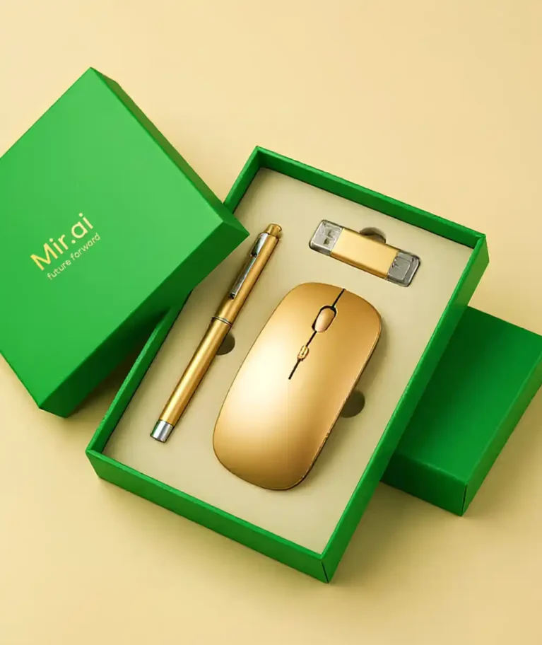 A high-angle studio shot displays a sleek corporate gift set arranged in a vibrant green box against a smooth, pale beige background. The box is open, revealing a cream-colored foam insert with custom cutouts holding three matching gold-colored office accessories: a slender ballpoint pen on the left, a minimalist wireless mouse in the center, and a rectangular USB flash drive with clear caps positioned at the top right. The box's lid, resting to the left of the base, features the branding "Mir.ai" followed by the slogan "future forward" printed in elegant gold lettering. The lighting is soft and even, highlighting the metallic sheen of the gold items and the matte texture of the green packaging. Corporate Gifting Boxes